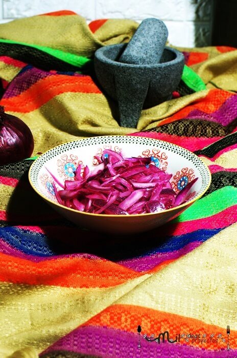 4. Decora con cebolla morada encurtida, cilantro picado y rodajas de aguacate.